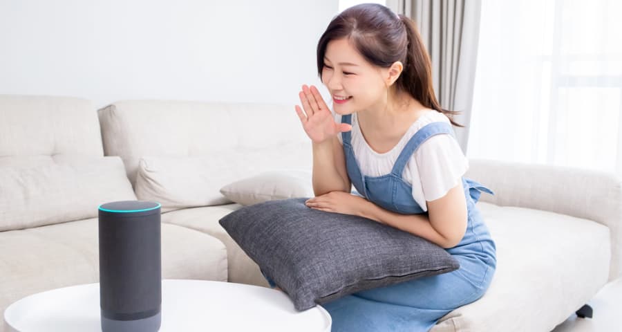 Young woman verbalizing a command to a smart assistant